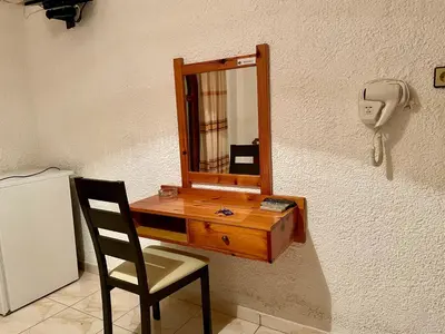 a mirror on a wall with a chair and a phone at Lefka in Kolymvari