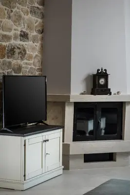 a living room with a tv on a white cabinet at Villa Antonousa - Private Pool Oasis in Kerá