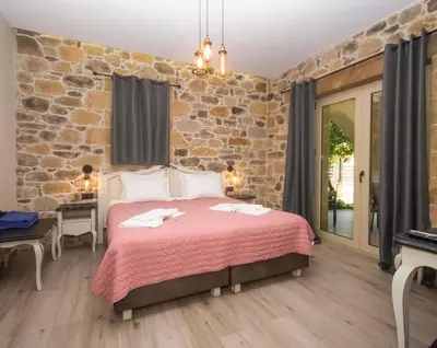 a bedroom with a large bed with a stone wall at Villa Antonousa - Private Pool Oasis in Kerá