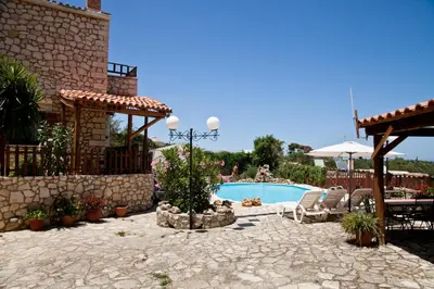 a patio with a pool and a table and chairs at Tsivaras Villas in Tsivarás