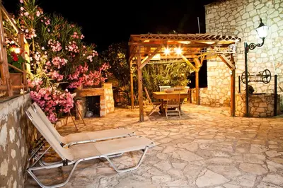 a patio with a chair and a table and a fireplace at Tsivaras Villas in Tsivarás