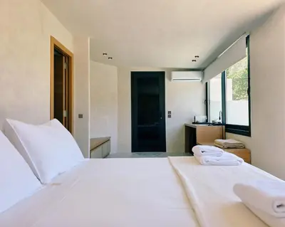 a bedroom with a large white bed with white sheets at Monastery Estate Retreat in Sougia