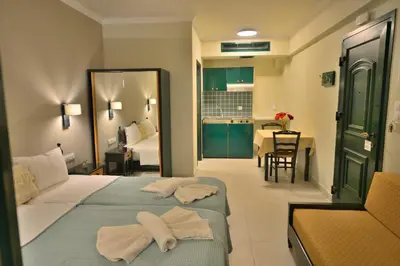 a hotel room with two beds and a dining room at Maria Beach Hotel in Kissamos