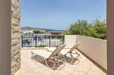 a patio with two chairs and a table on a balcony at Orion Star in Agia Marina Nea Kydonias