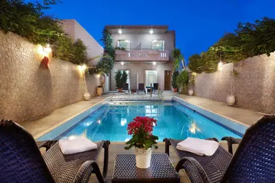 a swimming pool with chairs and a table and a house at Sun Nicolas in Kato Daratso