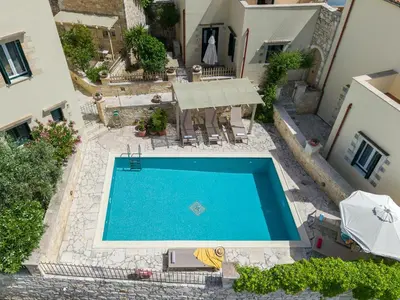 an overhead view of a swimming pool in a courtyard at Helianthos Villas in Douliana