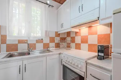 a kitchen with white cabinets and a sink at Helianthos Villas in Douliana