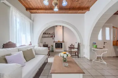 a living room with a white couch and a table at Helianthos Villas in Douliana