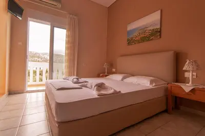 a bedroom with a bed and a large window at Oriental Bay in Palaiochóra