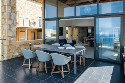 a dining room with a table and chairs at Villa Emilia front sea in Kalathas