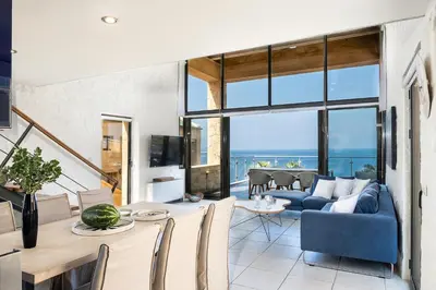 a living room with a blue couch and a table at Villa Emilia front sea in Kalathas