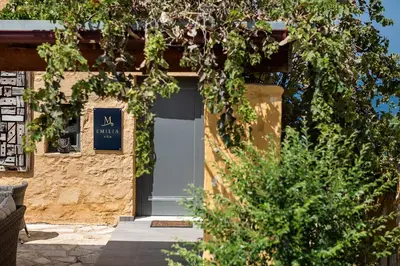 a door to a building with a sign on it at Villa Emilia front sea in Kalathas