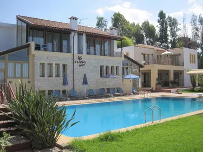 a villa with a swimming pool in front of a building at Vamos Palace Apartments in Vamos