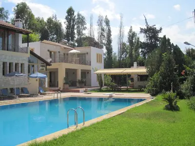 a large swimming pool in front of a house at Vamos Palace Apartments in Vamos