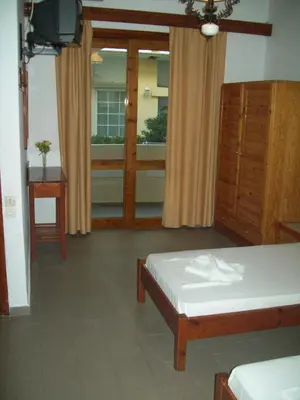 a bedroom with a bed and a dresser and a window at Kato Stalos Beach in Stalos