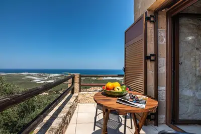 a bowl of fruit on a table on a balcony at The Stonemade Houses in Falasarna