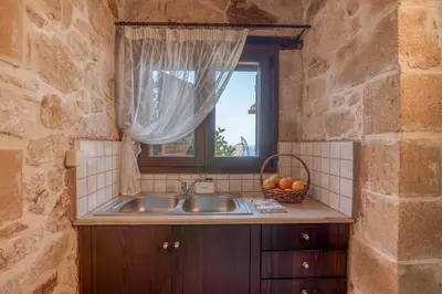 a kitchen with a sink and a window at The Stonemade Houses in Falasarna