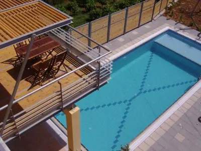 an overhead view of a swimming pool with two chairs and a deck at Sorta Apartments in Kato Daratso