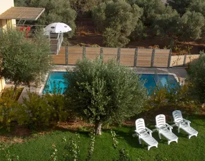 a row of lounge chairs next to a swimming pool at Sorta Apartments in Kato Daratso