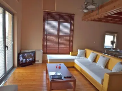a living room with a couch and a tv at Sorta Apartments in Kato Daratso