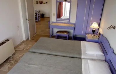a bedroom with a bed and a blue wall at Doreen Suites in Kalamaki Chanion
