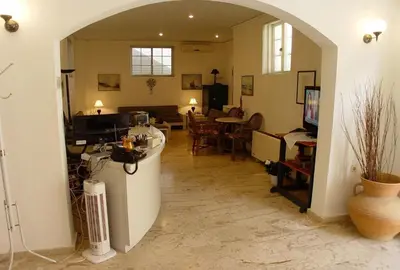a living room with an archway and a dining room at Doreen Suites in Kalamaki Chanion