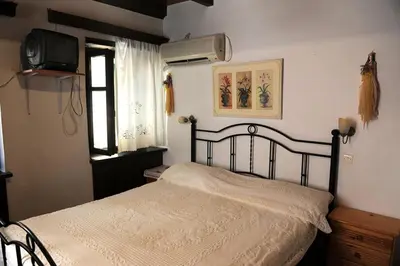 a bedroom with a bed and a tv on the wall at Eleonora in Chania Town