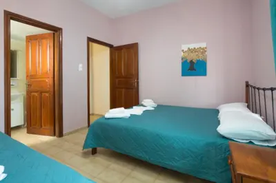 a bedroom with a blue bed and a bathroom at Eleni in Kissamos