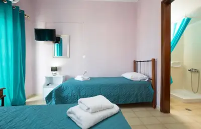 a room with two beds and a shower and a bathroom at Eleni in Kissamos