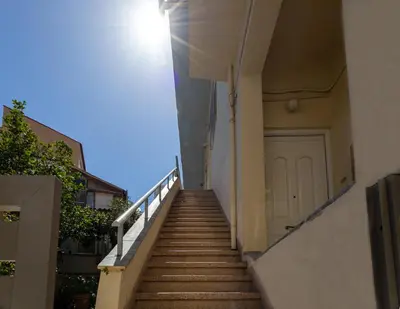 a stairway leading up to a building with a white door at In And Out in Chania Town