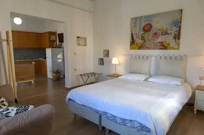 a bedroom with a white bed and a kitchen at In And Out in Chania Town