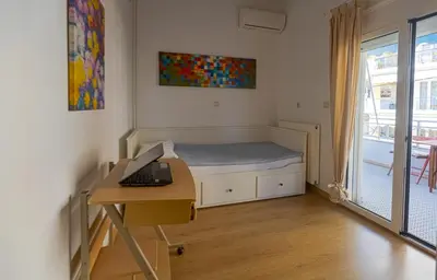 a bedroom with a bed and a desk with a laptop at In And Out in Chania Town