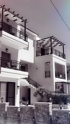 a white building with balconies on the side of it at Kandania Apartments in Kántanos