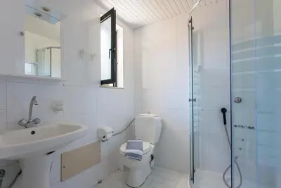 a bathroom with a toilet and a sink and a shower at Akasti Hotel in Kalamaki Chanion