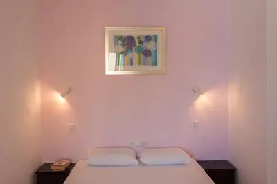 a bedroom with a bed and a picture on the wall at Akasti Hotel in Kalamaki Chanion