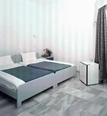 a bedroom with a large bed and a table at Akasti Hotel in Kalamaki Chanion