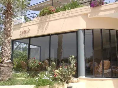 a building with glass windows and plants on it at Akasti Hotel in Kalamaki Chanion