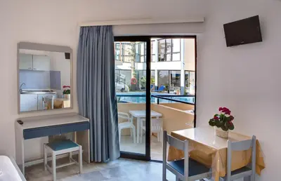 a small apartment with a table and a dining room at Akasti Hotel in Kalamaki Chanion