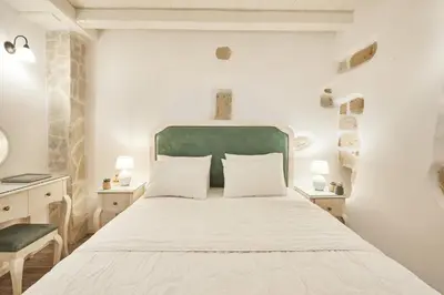a bedroom with a large white bed with two lamps at Estia Residence in Chania Old Town in Chania Town