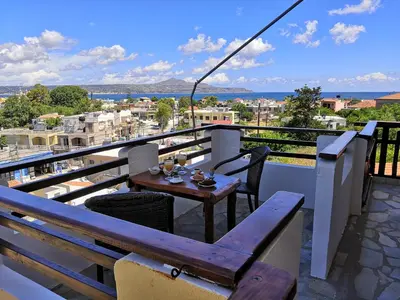 a table on a balcony with a view of the city at Sofia Kalyves in Kalyves