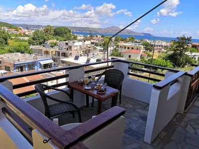 a table and chairs on a balcony with a view at Sofia Kalyves in Kalyves
