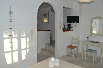 a living room with a table and a chair at Sofia Kalyves in Kalyves