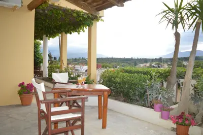 a table and chairs on a patio with a view at Sofia Kalyves in Kalyves