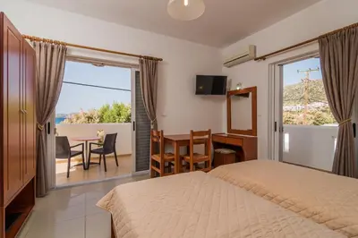 a bedroom with a bed and a desk and a table at Sifis Studios in Palaiochóra
