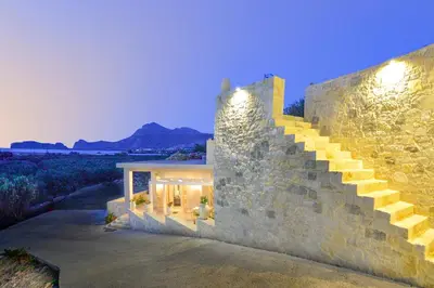 a stone house with a staircase on the side of it at Koukis House With Sea View in Falasarna