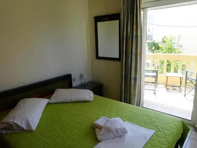 a bedroom with a green bed with towels on it at Platanias House on the Beach in Plataniás