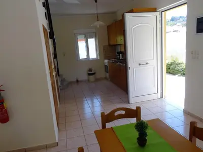 a kitchen with a table and a dining room at Platanias House on the Beach in Plataniás