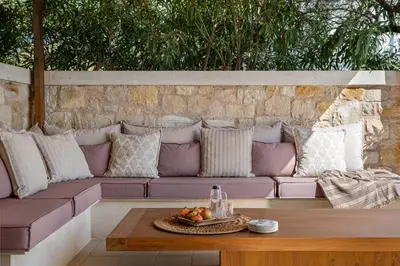 a purple couch with pillows and a table at Elements Villa in Galangádhos