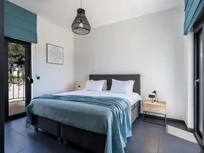 a bedroom with a bed with a blue blanket at Luxury Apartment with private pool in Tavronitis