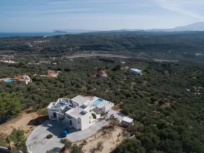 an aerial view of a white house on a hill at Luxury Apartment with private pool in Tavronitis